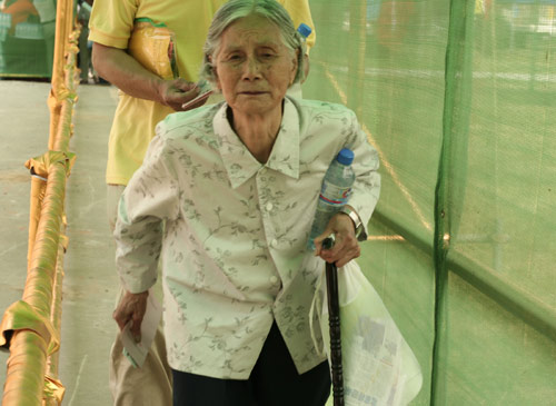 An aged woman waits to cast a vote on the demolishment and reconstruction of old buildings in Juixiaqiao Sub-district in Beijing, June 9, 2007. Local government and the real estate developer jointly organize the vote on Saturday to see if majority residents of over 5000 families accept the new compensation policy after failed attempts to reach an agreement through other ways. Both notary officials and supervisors are invited to monitor the vote that runs from 9 a.m. to 9 p.m. at six ballot booths. [Sun Yuqing/www.hwdly.com.cn]