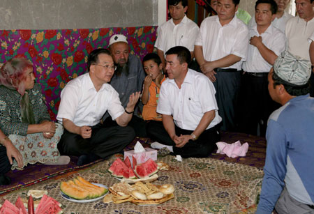 Chinese Premier Wen Jiabao (2nd L) talks with local people at a villager's home during his inspection tour to the northwestern Xinjiang Uygur Autonomous Region from last Thursday to Sunday. Wen Jiabao visited villages, schools, enterprises, hospitals and the Xinjiang production and construction corps of the army in a number of prefectures and cities to show his extensive care for local people's livelihood, education, medical service and the development of energy sources，Xinhua reported.[Xinhua]
