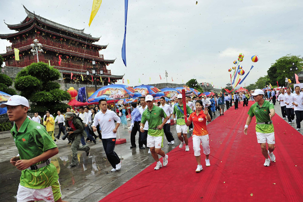 火炬首次雨中傳遞 “鲇魚”擋不住圣火僑鄉(xiāng)之旅