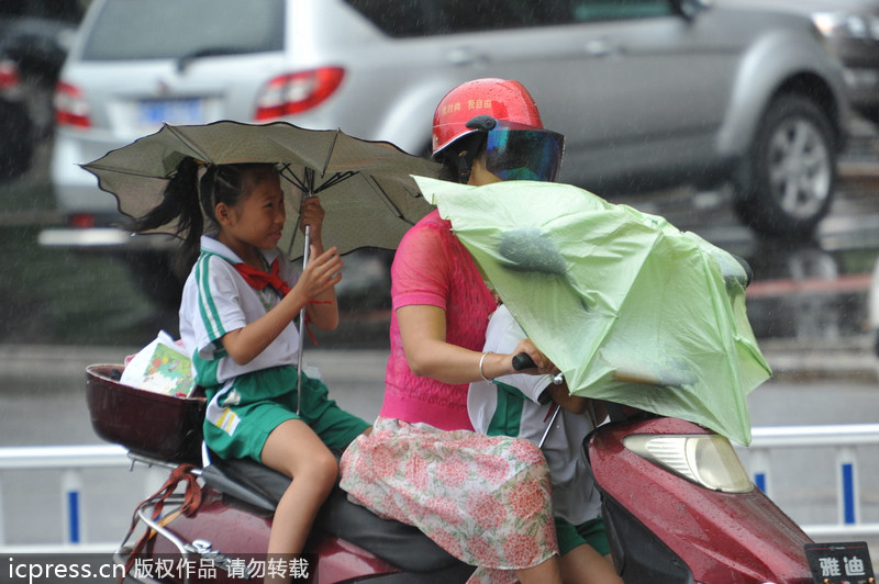 臺風(fēng)“百合”逼近海南 瓊海市民躲雨避風(fēng)各有高招