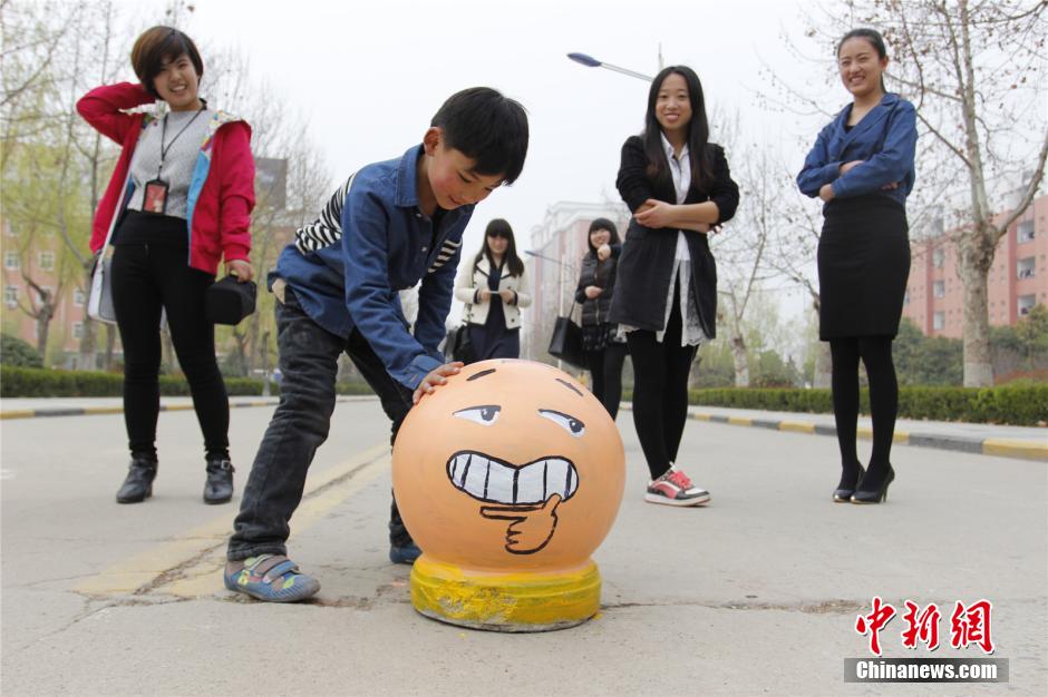 大學(xué)生做創(chuàng)意校園涂鴉 石墩變“萌寵”