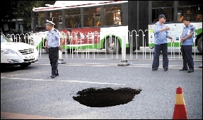 新街口外大街突現(xiàn)大坑 卡住過路汽車輪胎