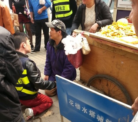 武漢攤販因車輛被扣下跪求情 城管與其“對(duì)跪”