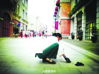清潔工蹲地鏟口香糖照片走紅 網(wǎng)友呼吁尊重勞動（圖）