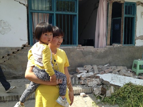 地震后墻壁出現(xiàn)窟窿 女子抱3歲女兒幸運逃生(圖)