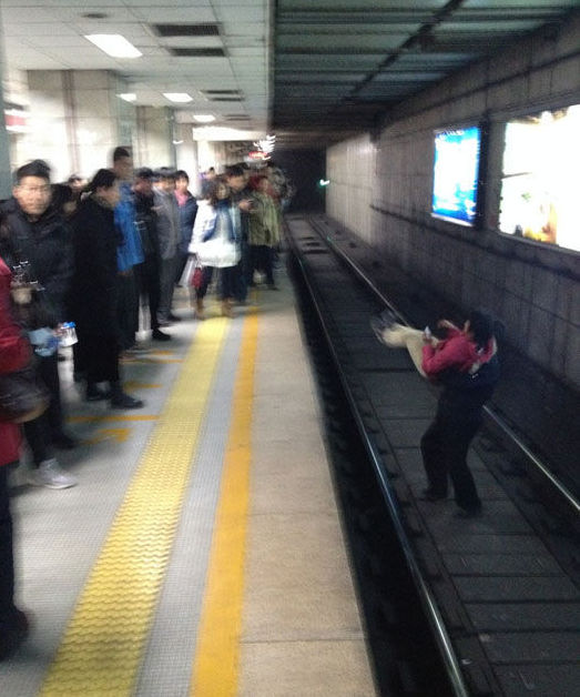 北京一女子地鐵臥軌被強行抱出