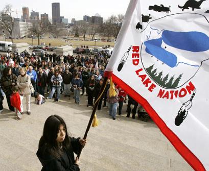 A flag-bearer 
 gathers 
 with several hundred people for a traditional American Indian prayer service on the steps of the State Capitol in St. Paul, Minn., Tuesday, March 22, 2005. The prayer service which was held in response to the shootings at Red Lake (Minn.) High School on Monday. Jeff Weise killed nine people at the school, including five students, before killing himself. [AP]