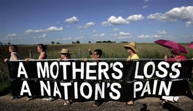 Supporter of 
 Cindy Sheehan march single file on the side of the road leading to President Bush's ranch in Crawford, Texas, Thursday, Aug. 18, 2005. Sheehan has left her vigil to California to be with her mother who suffered a stroke. (AP