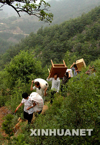 這是嵩縣木植街鄉(xiāng)的一批深山獨(dú)居戶搬運(yùn)物品下山，準(zhǔn)備遷入新居（2002年6月26日攝）。 河南省嵩縣是國家扶貧工作重點(diǎn)縣。為徹底改變部分生活在深山區(qū)、被“行路難、用電難、吃水難、上學(xué)難、就醫(yī)難”困擾的村民的生活狀況，從2002年開始，嵩縣把“異地安置、搬遷扶貧”作為山區(qū)扶貧開發(fā)的切入點(diǎn)和深山群眾脫貧致富的途徑，有計(jì)劃、分期分批地把他們搬遷到小城鎮(zhèn)和交通便利的村莊。5年來，嵩縣通過多種形式，新建移民新村53個(gè)，遷出深山貧困群眾3238戶、13151人。 新華社記者 王頌攝 