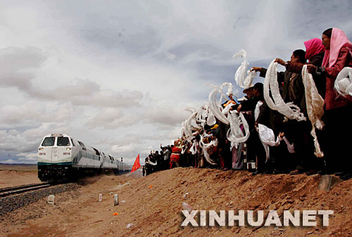 2006年7月1日，青藏鐵路全線通車，標志著西藏結束了不通火車的歷史。青藏鐵路自西寧至拉薩全長1956公里，包括西寧至格爾木和格爾木至拉薩兩段。這是在位于青海境內的沱沱河大橋橋頭，當?shù)厝罕姎g迎從格爾木出發(fā)的“青1”次列車（2006年7月1日攝）。 新華社發(fā) 