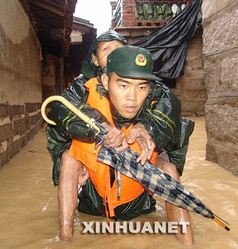  2006年7月16日，在福建省龍海市程溪鎮(zhèn)官園村，福建省武警總隊漳州支隊官兵奮勇轉移被洪水圍困的群眾。 新華社發(fā) 