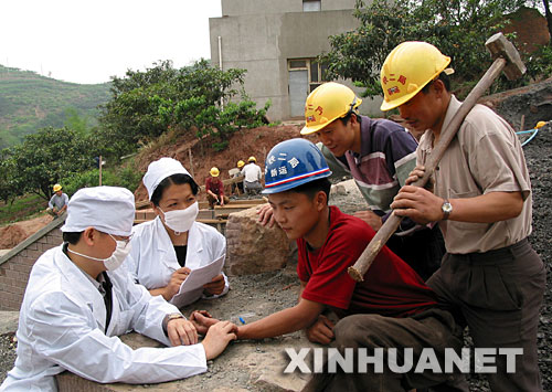  2003年5月9日，中鐵二局巡回防疫小分隊(duì)的醫(yī)務(wù)人員在成都市龍泉驛區(qū)白工堰建設(shè)工地為施工人員檢查身體。為預(yù)防非典傳播，中鐵二局醫(yī)務(wù)人員深入各建設(shè)工地，為施工人員和駐地山村群眾免費(fèi)檢查身體，宣傳防疫知識(shí)。 新華社發(fā) 