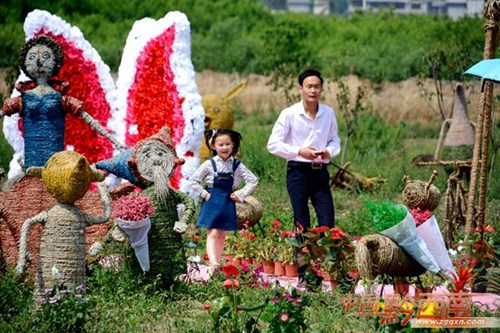 Tourists have fun with straw sculptures in Xingyi