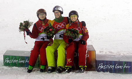 Evelyne Leu (C) of Switzerland celebrates during the final of the women's aerials freestyle competition at the Torino 2006 Winter Olympic Games in Sauze d�Oulx, Italy February 22, 2006. Leu is flanked by China's Li Nina (L) and Australia's Alisa Camplin (R).[Reuters]