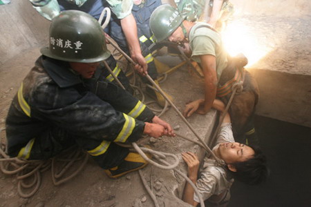 Firemen rescue Liu Jie, who was trapped in a bridge abutment for 26 hours, in Chongqing��July 16, 2006. Liu Jie fell into the abutment by accident and attracted people's attention by setting on his clothes on fire with a lighter. [Wang Yuanling/Chongqing Times]