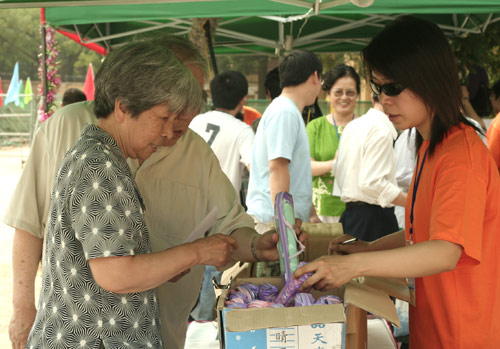Voters choose the umbrella as a souvenir after voting on demolishment and reconstruction of old buildings in Juixiaqiao Sub-district in Beijing, June 9, 2007. Local government and the real estate developer jointly organize the vote on Saturday to see if majority residents of over 5000 families accept the new compensation policy after failed attempts to reach an agreement through other ways. Both notary officials and supervisors are invited to monitor the vote that runs from 9 a.m. to 9 p.m. at six ballot booths. [Sun Yuqing/www.hwdly.com.cn]