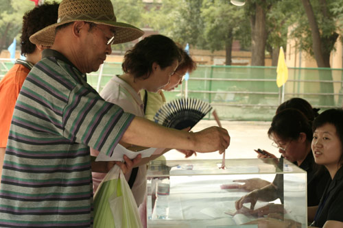 A voter casts his vote on demolishment and reconstruction of old buildings in Juixiaqiao Sub-district in Beijing, June 9, 2007. Local government and the real estate developer jointly organize the vote on Saturday to see if majority residents of over 5000 families accept the new compensation policy after failed attempts to reach an agreement through other ways. Both notary officials and supervisors are invited to monitor the vote that runs from 9 a.m. to 9 p.m. at six ballot booths. [Sun Yuqing/www.hwdly.com.cn]