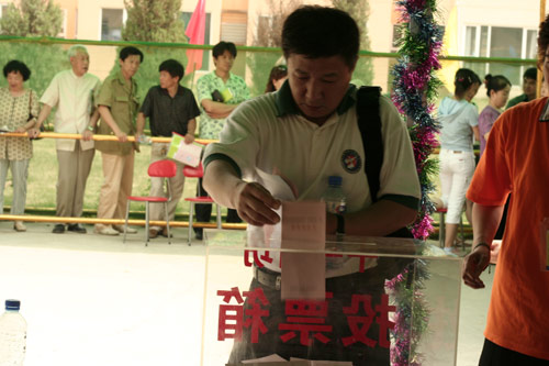A voter casts his vote on demolishment and reconstruction of old buildings in Juixiaqiao Sub-district in Beijing, June 9, 2007. Local government and the real estate developer jointly organize the vote on Saturday to see if majority residents of over 5000 families accept the new compensation policy after failed attempts to reach an agreement through other ways. Both notary officials and supervisors are invited to monitor the vote that runs from 9 a.m. to 9 p.m. at six ballot booths. [Sun Yuqing/www.hwdly.com.cn]